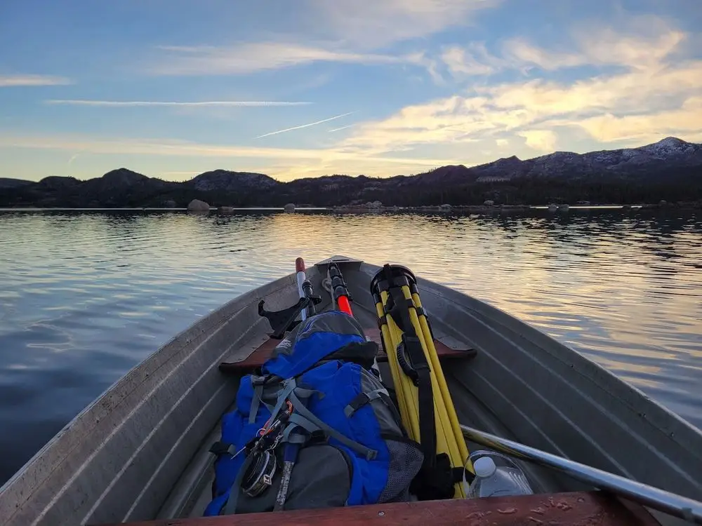 Survey gear in the bow of a boat on a mountain lake at sunrise