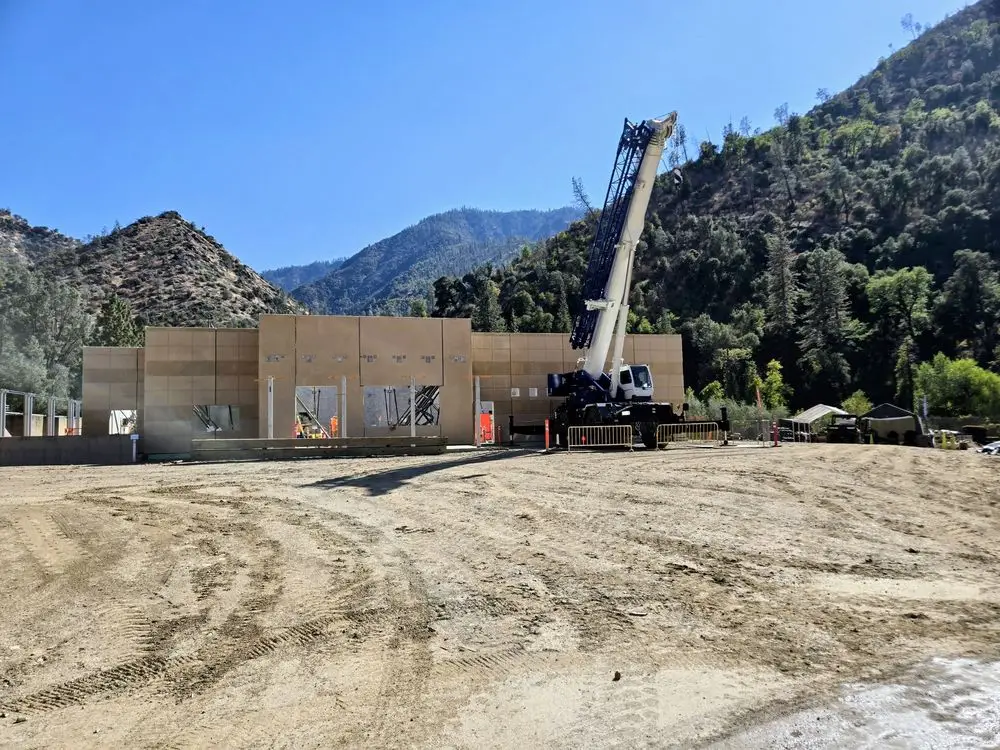 Precast concrete treatment plant building under construction with a mobile crane, in the Merced River canyon at El Portal