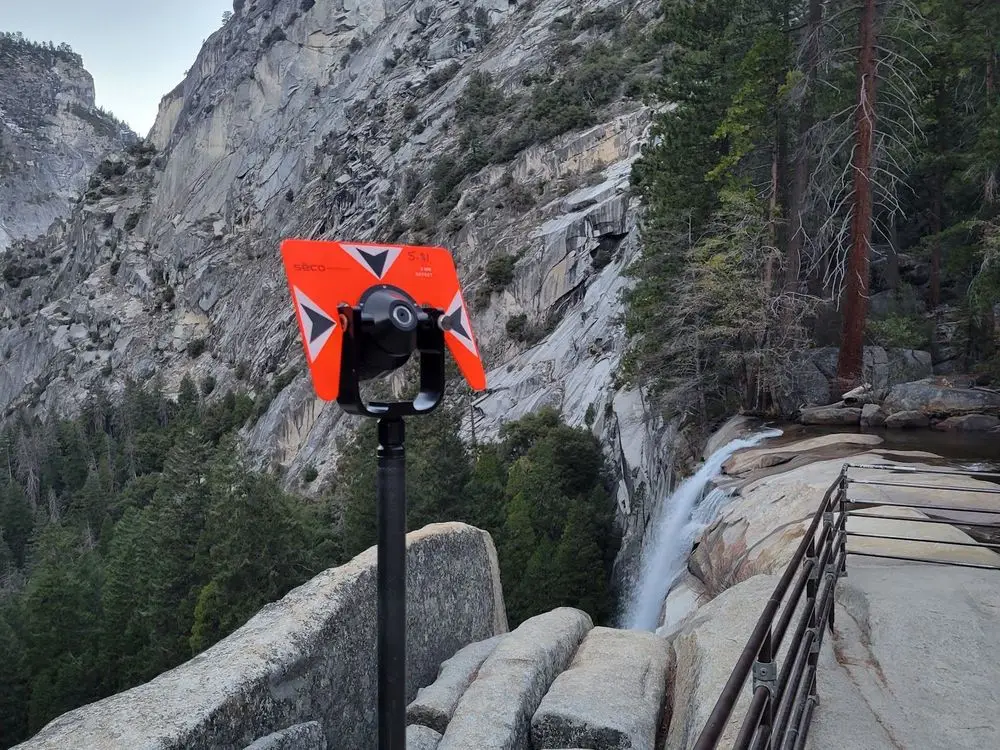 Orange survey prism above Vernal Fall with granite cliffs behind